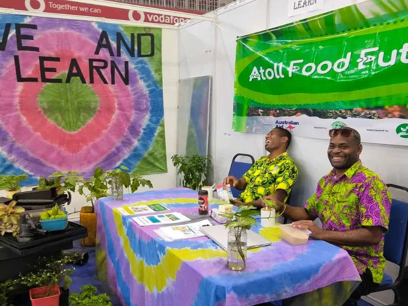 Live & Learn staff sitting in the Atoll Food Futures booth
