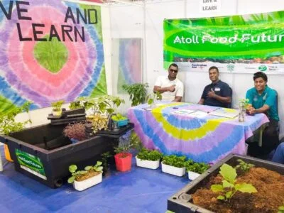 Live & Learn staff at sitting in the Atoll Food Futures display booth