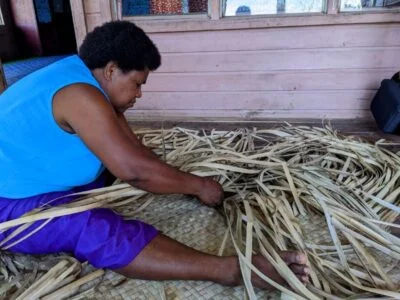 A woman weaving a pandanus leaf mat