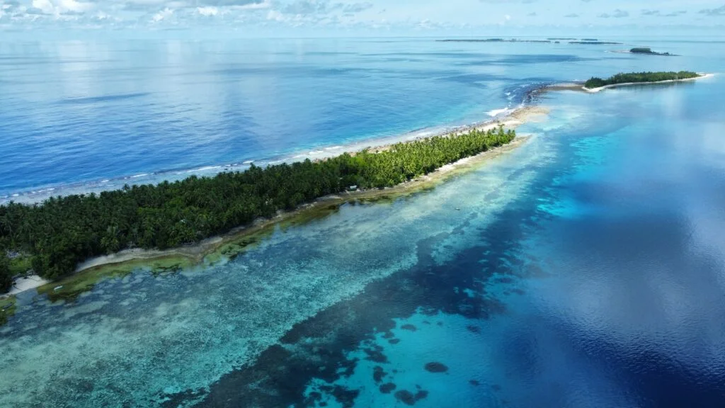 An aerial photo of an atoll surrounded by ocean