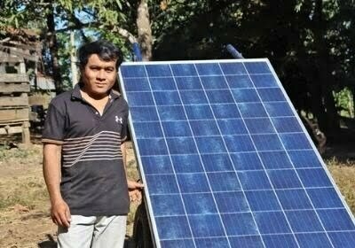 Mr. Pleung Eal stands next to his solar panel