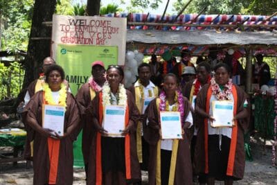 A group of graduates holding their certificates at their graduation ceremony