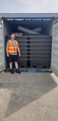 Man standing in front of shipping container full of food cubes