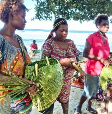 Women carry recently made handicrafts