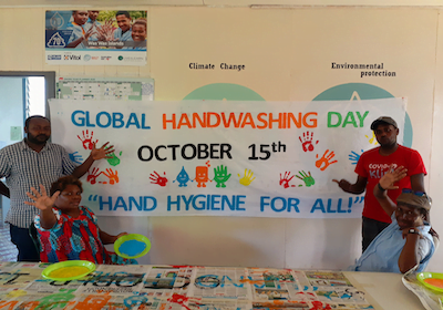 Live & Learn staff stand in front of a banner that says Global Handwashing Day